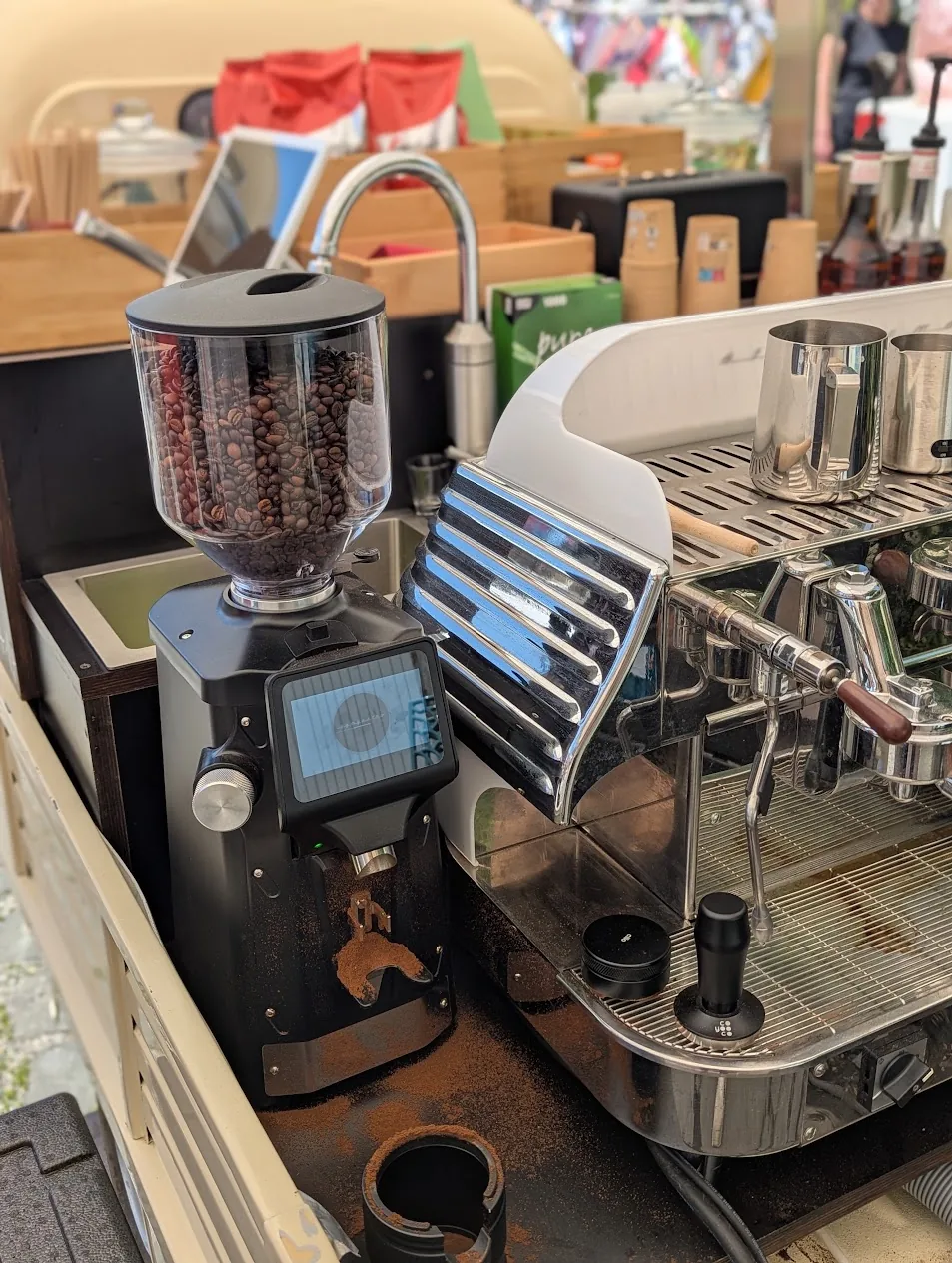 Kaffeemühle mit Bohnen neben der Siebträgermaschine